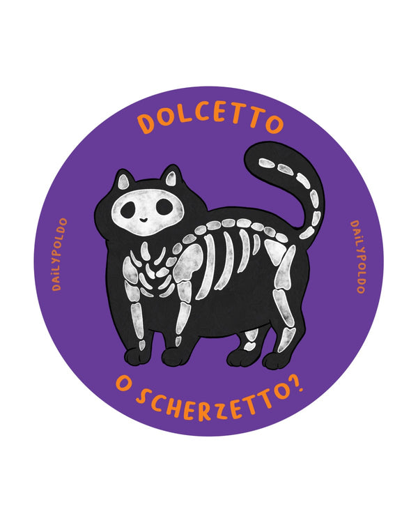 Gatto tondo con costume da scheletro nero e ossa bianche su fondo viola, con la scritta Dolcetto o scherzetto?